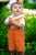 Boy wearing orange hand-smocked spider web Halloween shortall